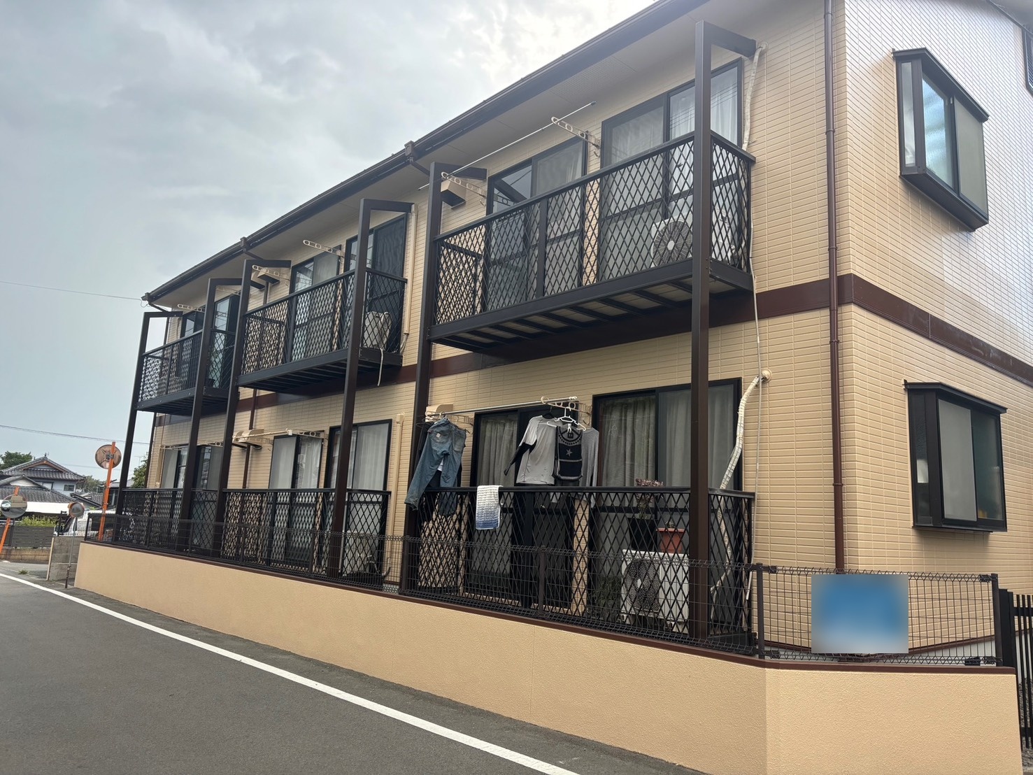 施工後の2階建て賃貸アパート外観(熊本県菊池市泗水)ミッドビスケットの明るい外壁とダークブラウンの鉄部