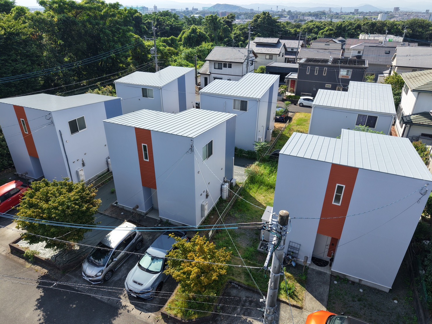 施工後の戸建て賃貸住宅(熊本県合志市須屋)上空から見た白基調にオレンジのアクセントを効かせた外観
